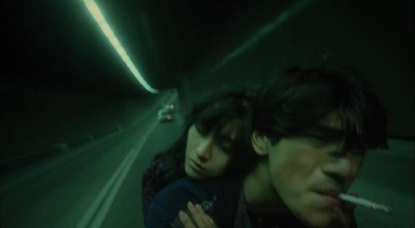 Michelle Reis y Takeshi Kaneshiro en moto por un túnel de Hong Kong.